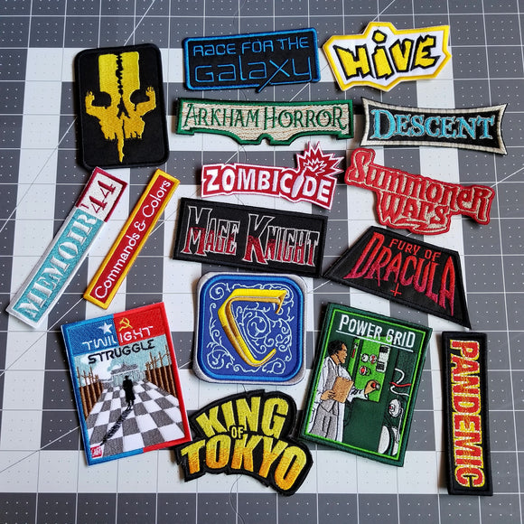 A collection of board game-inspired embroidered patches from Thread By Dawn.