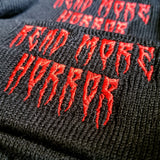 Black knit beanie with the words read more horror embroidered in creepy red lettering.