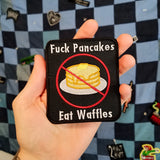Embroidered patch showing a crossed-out stack of pancakes with the words eff pancakes, eat waffles.