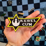 Rebel Cum Star Wars parody embroidered patch shown in the palm of a hand for size reference.