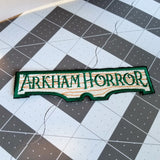 Embroidered patch for the Arkham Horror series of board games and card games.