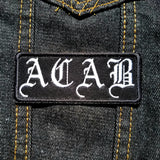 White on black ACAB patch in old english lettering.