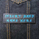 Blue on black rectangular embroidered patch that says insert band name here.