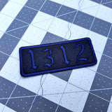 1312 embroidered patch in an old English font, navy blue lettering on black material.