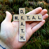Embroidered patch of the words death metal in Scrabble letters, shown in the palm of a hand for size reference.