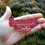 Embroidered patch of the board game Summoner Wars logo. Shown in the palm of a hand for size reference.