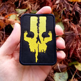 Yellow on black embroidered logo patch for the adventure boardgame The 7th Continent. Shown in the palm of a hand for size reference.