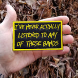 Yellow on black embroidered patch that says I've never actually listened to any of these bands.