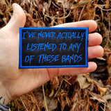 Blue on black embroidered patch that says I've never actually listened to any of these bands.