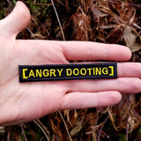 Angry dooting embroidered meme patch from Army of Darkness, part of the Evil Dead horror movie series, shown in the palm of a hand for size reference.