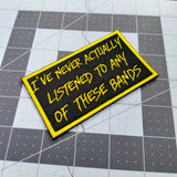 Yellow on black embroidered patch that says I've never actually listened to any of these bands.