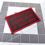 Red on black embroidered patch that says I've never actually listened to any of these bands.