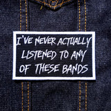 White on black embroidered patch that says I've never actually listened to any of these bands.
