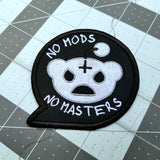 White on black embroidered patch in the shape of a speech bubble with a parody of the Reddit logo and the phrase, no mods no masters.
