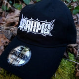 Black baseball cap with a heavy metal style logo for the classical music composer Brahms embroidered on the front in white thread.