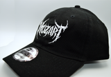 Left side view of a black baseball hat with a heavy metal style logo for the classical music composer Mozart embroidered on the front in white thread.