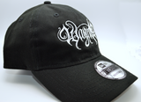 Right side view of a black baseball hat with a heavy metal style logo for the classical music composer Wagner embroidered on the front in white thread.