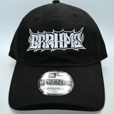 Front view of a black baseball hat with a heavy metal style logo for the classical music composer Brahms embroidered on the front in white thread.
