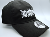 Right side view of a black baseball hat with a heavy metal style logo for the classical music composer Brahms embroidered on the front in white thread.