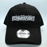 Front view of a black baseball hat with a heavy metal style logo for the classical music composer Tchaikovsky embroidered on the front in white thread.