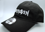 Left side view of a black baseball hat with a heavy metal style logo for the classical music composer Beethoven embroidered on the front in white thread.