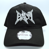 Front view of a black baseball hat with a heavy metal style logo for the classical music composer Bach embroidered on the front in white thread.