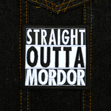 Square black and white embroidered patch that says straight outta mordor. Shown on a denim jacket.