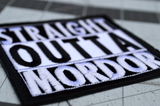 Close up detail of a square black and white embroidered patch that says straight outta mordor.