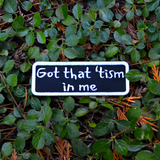 Rectangular black patch with a white border and the words, got that tism in me, embroidered in white thread.