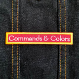 Embroidered text patch for the classic historical wargame Commands and Colors in white and gold on red fabric.