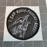 Circular white on black embroidered patch of a raven screaming I said never-fucking-more!