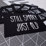 White on black screen printed canvas patch that says still spooky, just old.