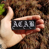 ACAB embroidered patch in the palm of a hand for size reference.