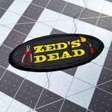 A Zed's Dead embroidered patch with a pair of pliers and a blowtorch, inspired by Quentin Tarantino's movie Pulp Fiction.