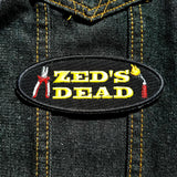 A Zed's Dead embroidered patch with a pair of pliers and a blowtorch, inspired by Quentin Tarantino's movie Pulp Fiction.