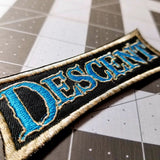 Close up details of an embroidered logo patch for the classic dungeon crawler boardgame Descent.