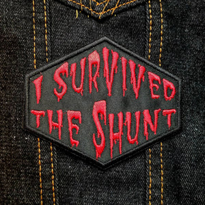 Red on black embroidered patch that says I survived the shunt, in reference to the horror movie Society.