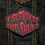 Red on black embroidered patch that says I survived the shunt, in reference to the horror movie Society.