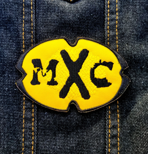 The MXC (Most Extreme Elimination) logo as an embroidered patch.