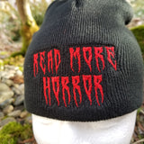 Black knit beanie with the words read more horror embroidered in creepy red lettering.