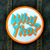 Circular embroidered patch with glittery blue and flat orange lettering saying why though on white fabric.