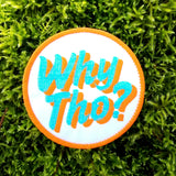 Circular embroidered patch with glittery blue and flat orange lettering saying why though on white fabric.