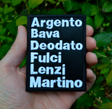 Rectangular white on black embroidered patch with the names of classic Italian film directors, including Argento, Bava, Deodato, Fulci, Lenzi, and Martino. Shown in the palm of a hand for size reference.