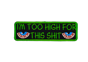 Rectangular green-bordered embroidered patch with a pair of bloodshot eyes and the text, I'm too high for this shit in green thread.