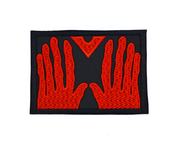 Rectangular black embroidered patch of the red hands of Manos, the Hands of Fate.