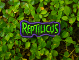 Embroidered patch with 'REPTILICUS' text in green on a black background with purple border.