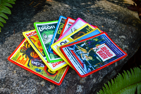 A collection of printed patches with embroidered borders featuring theatrical poster art from classic horror and sci-fi movies from the 1930s to the 1960s.
