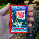 An example of a printed patch with embroidered borders featuring theatrical poster art from a classic horror movie, shown in the palm of a hand for size reference.