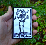 Rectangular black and white embroidered patch of a smoking skeleton in a medieval woodcut design style with the phrase doeth whatever spelled out in old English lettering. Shown in a hand for size reference.