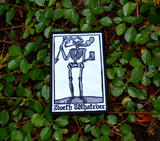 Rectangular black and white embroidered patch of a smoking skeleton in a medieval woodcut design style with the phrase doeth whatever spelled out in old English lettering.